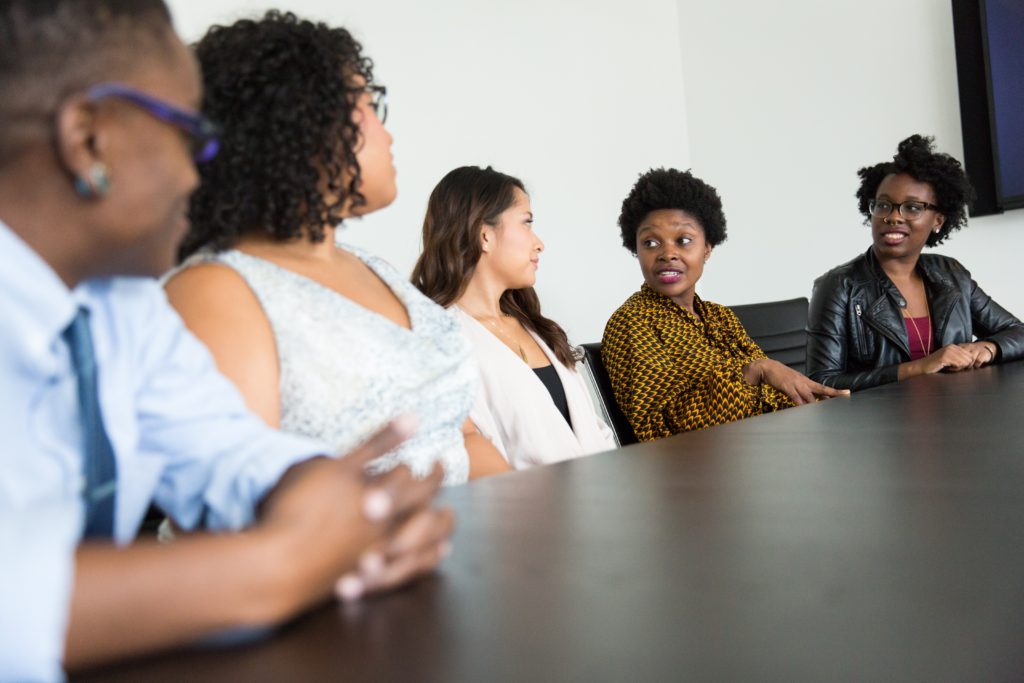 People from different demographics sitting together at a meeting table